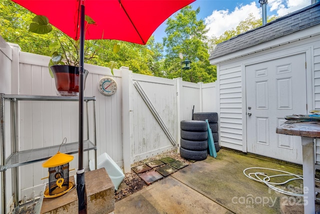 view of patio featuring fence and a gate