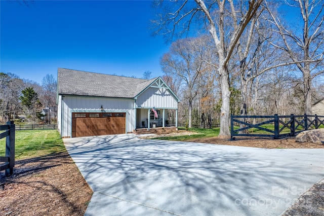 modern farmhouse featuring a garage, a porch, driveway, and fence