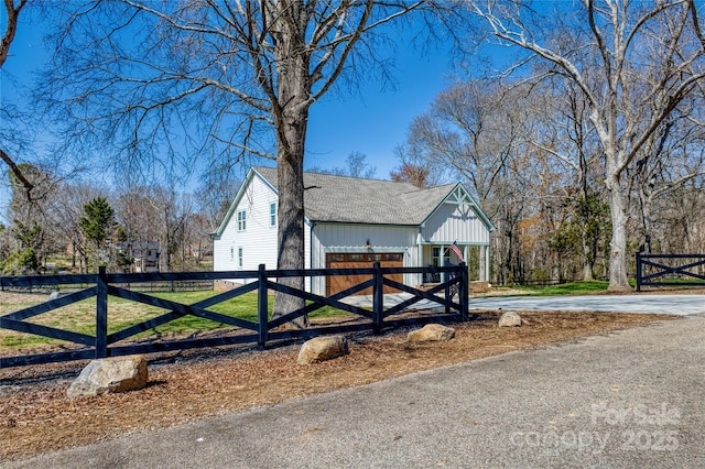 view of property exterior featuring fence, driveway, and roof with shingles