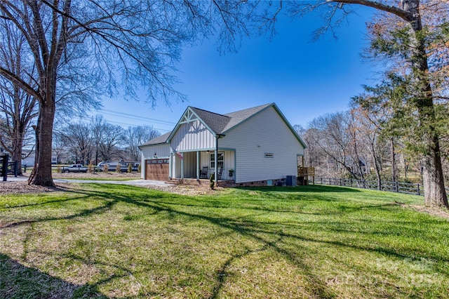 back of property with an attached garage, a yard, and fence