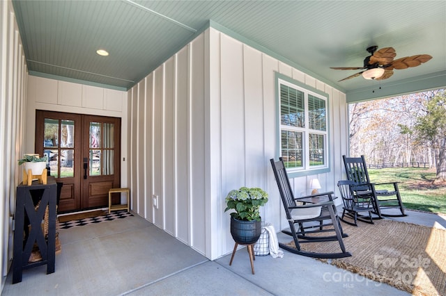 doorway to property featuring french doors, board and batten siding, covered porch, and a ceiling fan