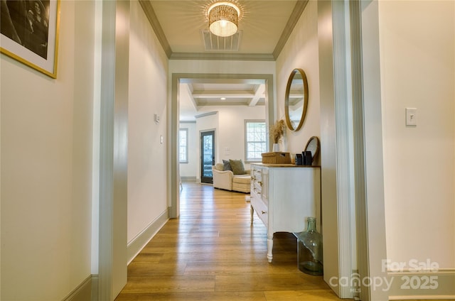 hall with light wood finished floors, visible vents, crown molding, baseboards, and beamed ceiling