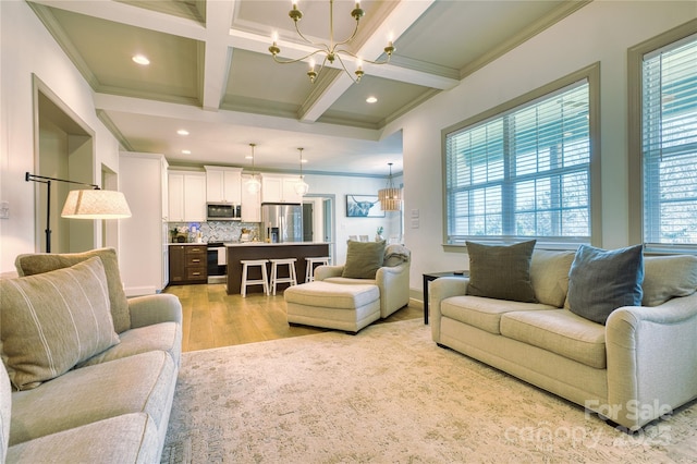 living room with crown molding, beamed ceiling, light wood-style floors, an inviting chandelier, and coffered ceiling