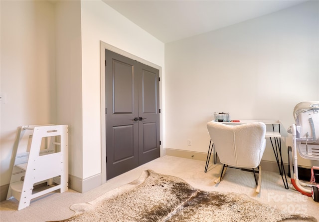 carpeted office space featuring baseboards