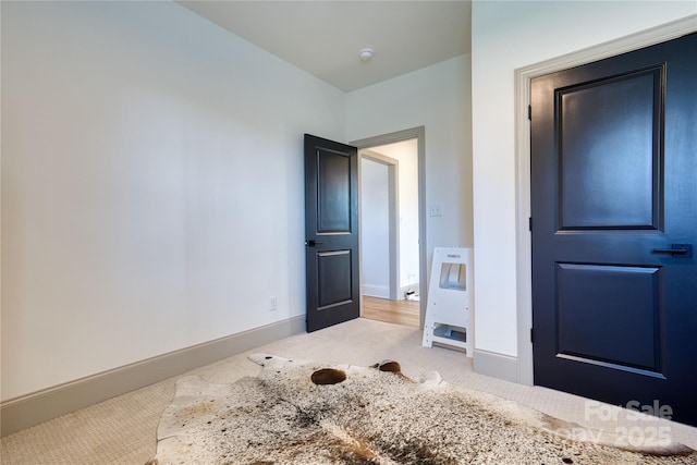 unfurnished bedroom with light colored carpet and baseboards