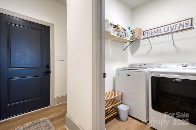 washroom with laundry area, light wood finished floors, and washing machine and clothes dryer