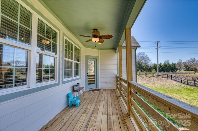 wooden deck featuring covered porch and fence