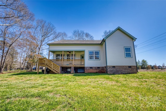 rear view of property featuring stairway, a ceiling fan, a wooden deck, crawl space, and a lawn