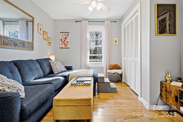 living room featuring light wood-type flooring and a ceiling fan