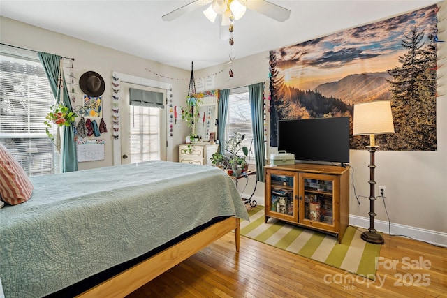 bedroom featuring baseboards, hardwood / wood-style floors, and a ceiling fan