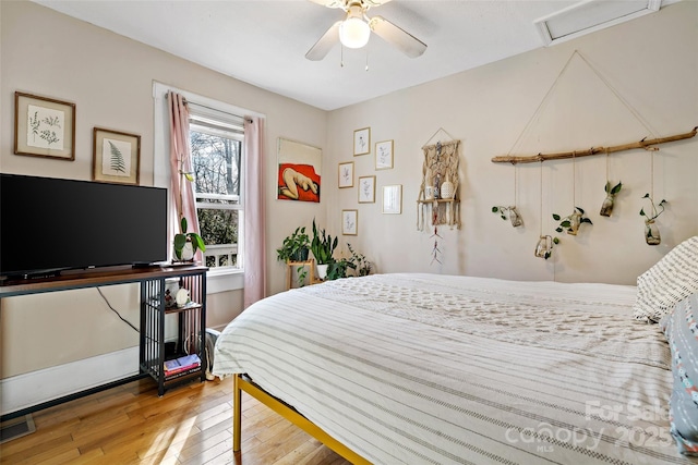 bedroom with visible vents, a ceiling fan, and wood finished floors