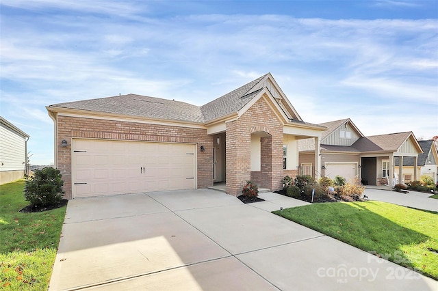 view of front of house with a garage, brick siding, a shingled roof, concrete driveway, and a front yard