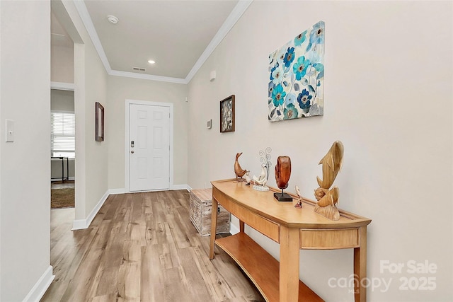 foyer featuring baseboards, visible vents, crown molding, light wood-style floors, and recessed lighting