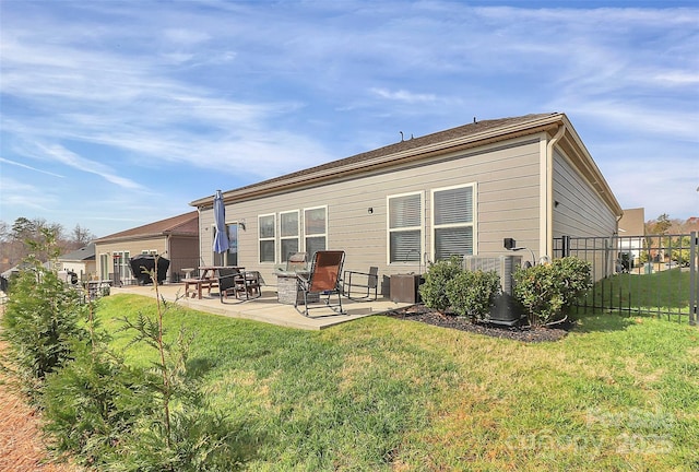 back of property with a yard, a patio area, and fence