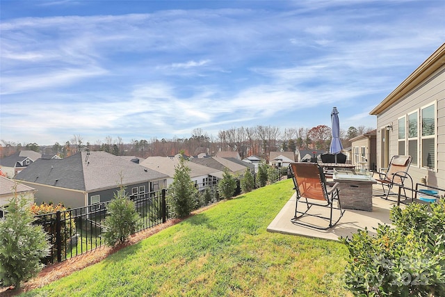 view of yard with a patio area, a fenced backyard, and a residential view