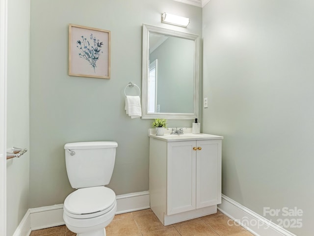 half bath featuring vanity, tile patterned flooring, toilet, and baseboards