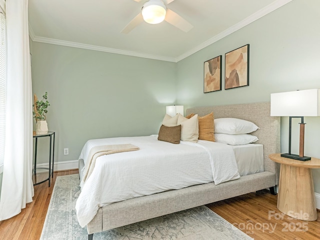 bedroom featuring a ceiling fan, baseboards, ornamental molding, and wood finished floors