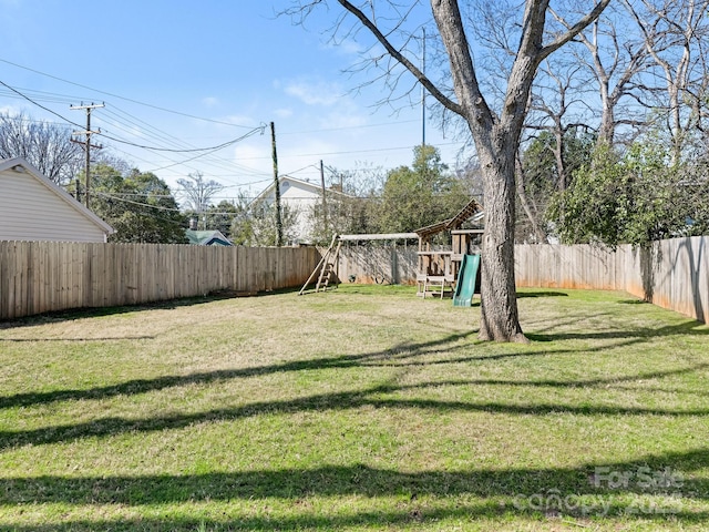 view of yard featuring a playground and a fenced backyard