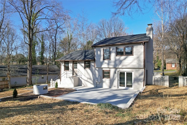 back of property featuring a chimney, cooling unit, a patio, and brick siding