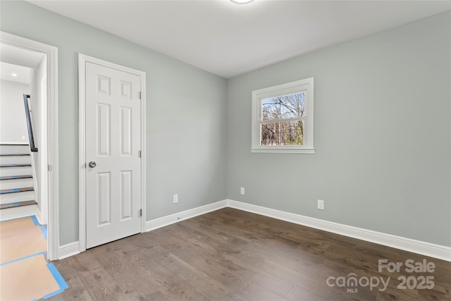 unfurnished bedroom with wood finished floors and baseboards