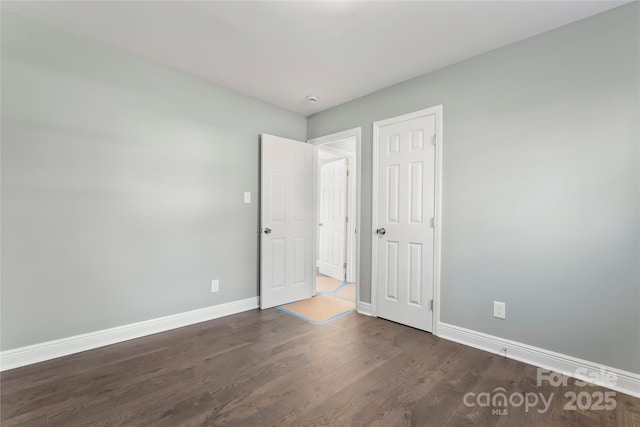 unfurnished bedroom featuring dark wood-style floors and baseboards