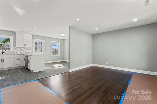 interior space featuring dark wood-style floors, plenty of natural light, a sink, and visible vents