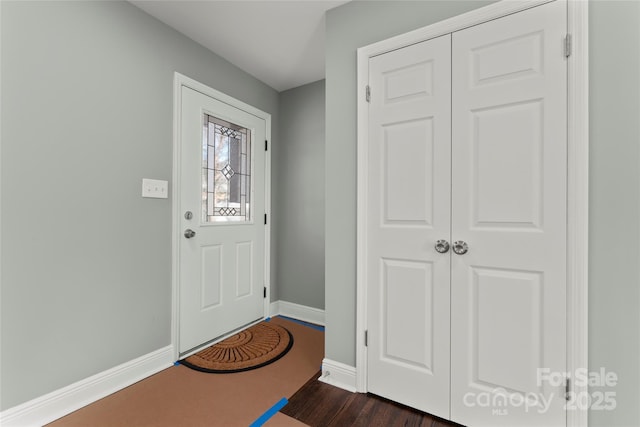 entrance foyer with dark wood-type flooring and baseboards