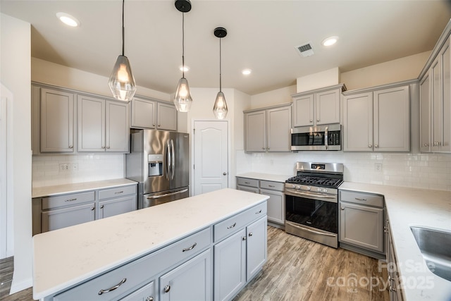 kitchen featuring visible vents, gray cabinets, appliances with stainless steel finishes, and light wood-type flooring