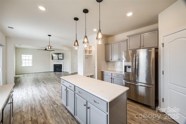 kitchen featuring visible vents, gray cabinetry, a ceiling fan, stainless steel fridge, and decorative backsplash