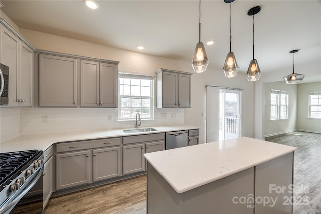 kitchen featuring a sink, appliances with stainless steel finishes, gray cabinets, and light wood finished floors