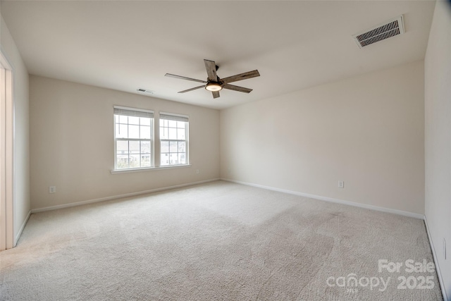 empty room with visible vents, carpet, and ceiling fan