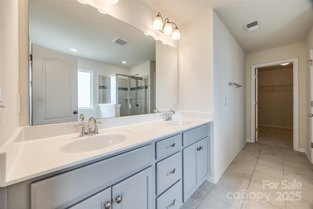 full bathroom with visible vents, a stall shower, and a sink