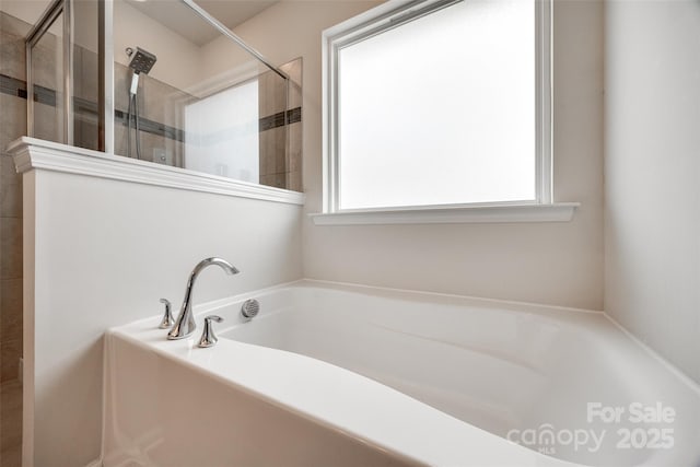 bathroom with a wealth of natural light, a bath, and a tile shower