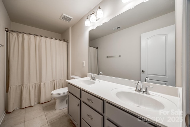 bathroom featuring tile patterned floors, visible vents, and a sink