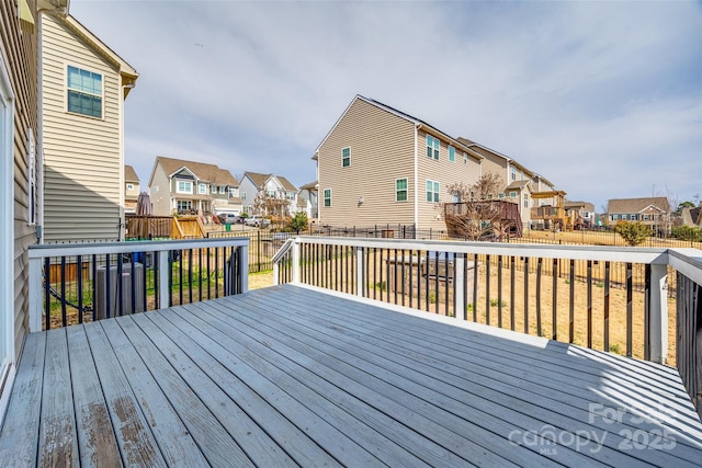 wooden deck with a residential view and a fenced backyard