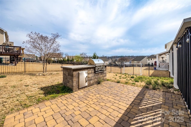 view of patio / terrace featuring grilling area, a fenced backyard, and exterior kitchen