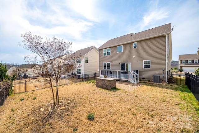 back of property with a yard, central AC unit, and a fenced backyard