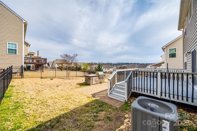 view of yard featuring central AC unit, a residential view, a fenced backyard, and a wooden deck