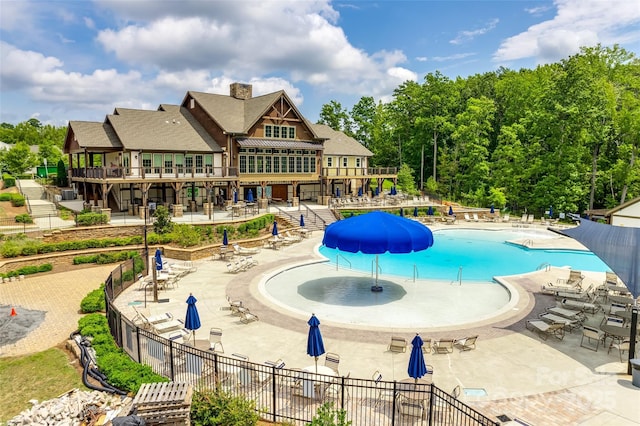 pool with a patio and fence