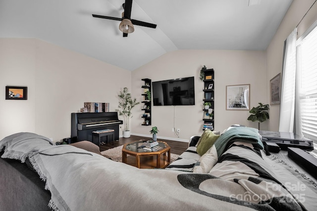 living area featuring lofted ceiling, ceiling fan, baseboards, and wood finished floors