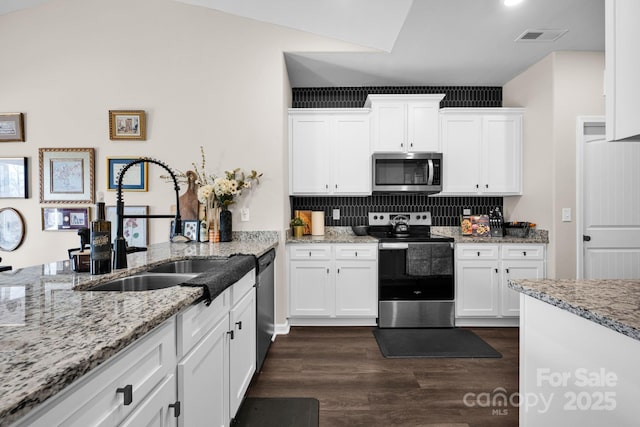 kitchen featuring visible vents, appliances with stainless steel finishes, dark wood-type flooring, white cabinetry, and a sink