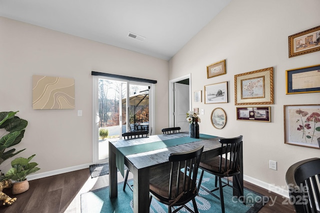 dining room featuring baseboards, visible vents, vaulted ceiling, and dark wood-style flooring