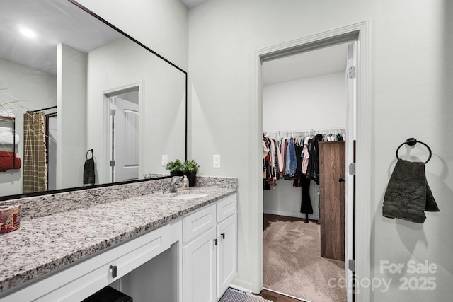 bathroom with a spacious closet and vanity