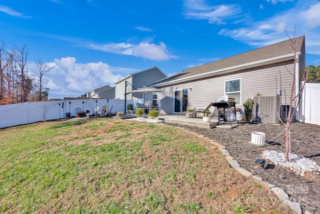 rear view of property with a fenced backyard, a lawn, and a patio