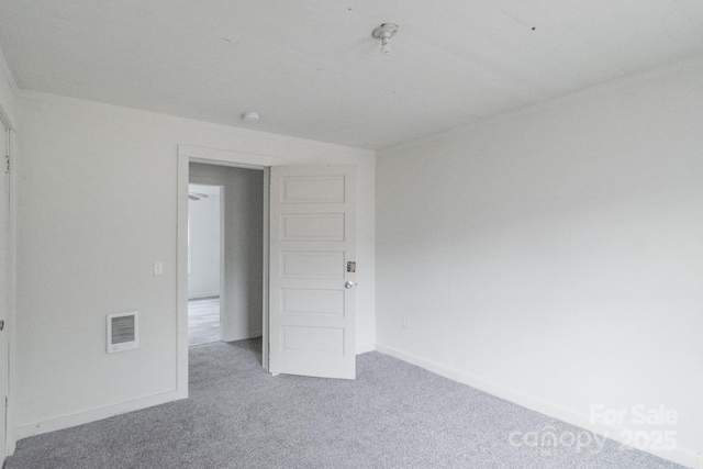 carpeted empty room featuring visible vents and baseboards