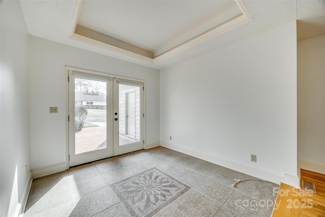 unfurnished room with visible vents, french doors, baseboards, and a tray ceiling