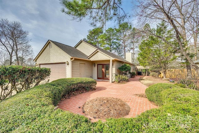 view of front of home with an attached garage and a chimney