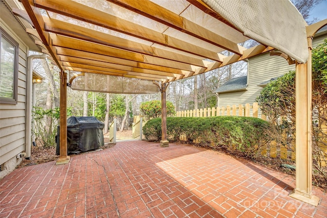 view of patio featuring grilling area, fence, and a pergola