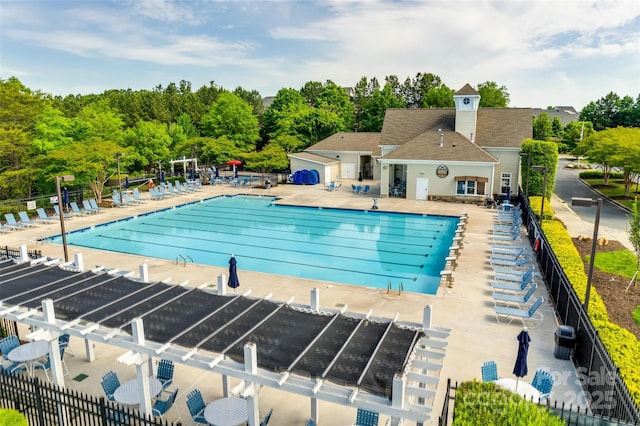 community pool featuring a patio, cooling unit, and fence