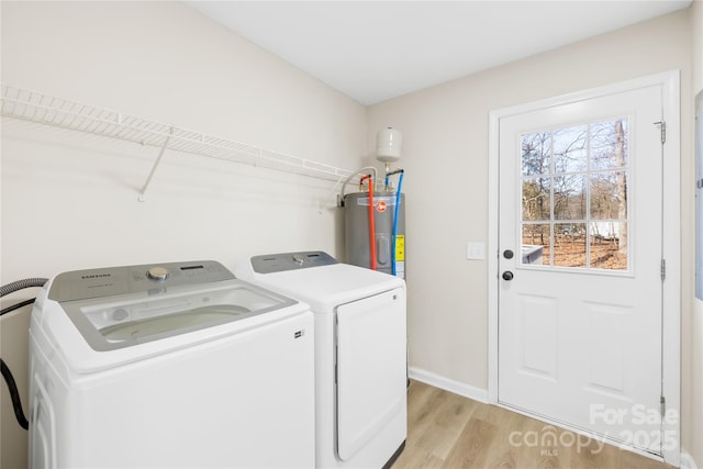 laundry room with washer and clothes dryer, water heater, light wood-style flooring, laundry area, and baseboards